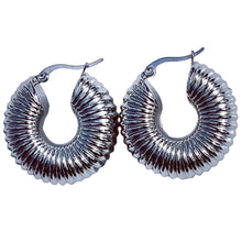 Load image into Gallery viewer, A pair of silver-colored, chunky croissant hoop earrings with a smooth finish on a white surface.